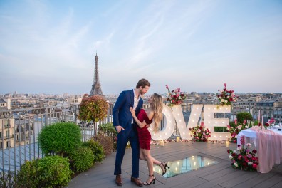Newly engaged couple posing for their engagement pictures in Paris, on a private rooftop terrace - LOVE letters