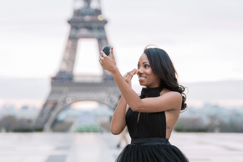 Beautiful black girl getting ready to take Paris portraits at the Eiffel Tower