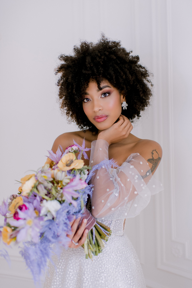 Beautiful bride holding purple bouquet posing for photos