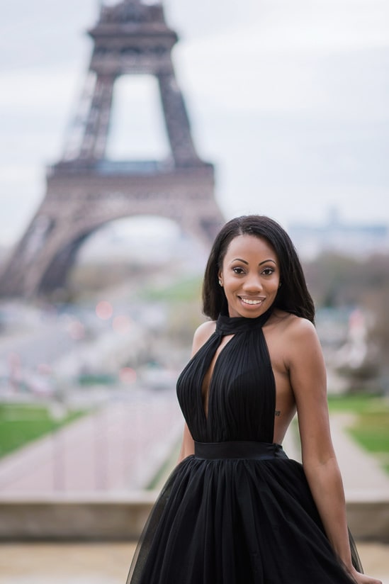 Beautiful girl posing in front of the Eiffel Tower in her black tulle dress