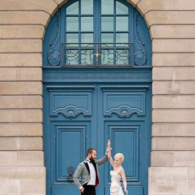 best photography spots in Paris with bride and groom dancing in front of blue door