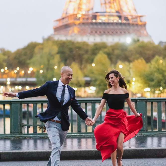 best places to take pictures in paris cute couple running across the street on the pont bir hakeim
