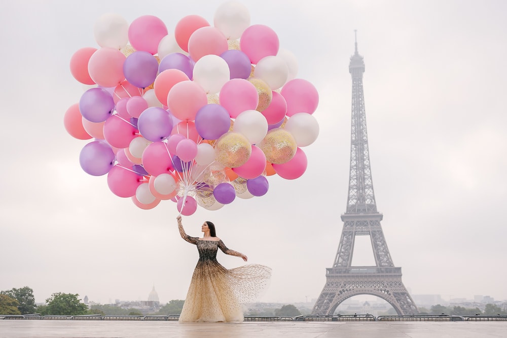 Bride with a huge bouquet of colorful balloons dancing in Paris