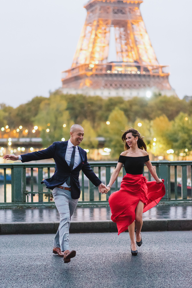 Couple running across street in Paris during engagement photos