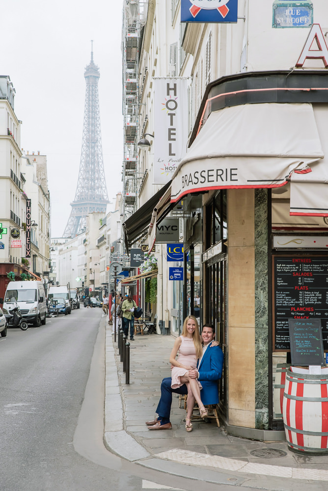 Couple sitting in a cafe on a street with eiffel tower view