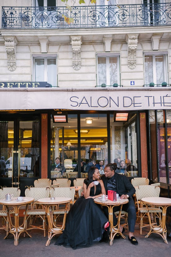 Cute couple photoshoot in a parisian café. Sharing macarons and hot chocolate at Carette Paris in Place de Trocadéro