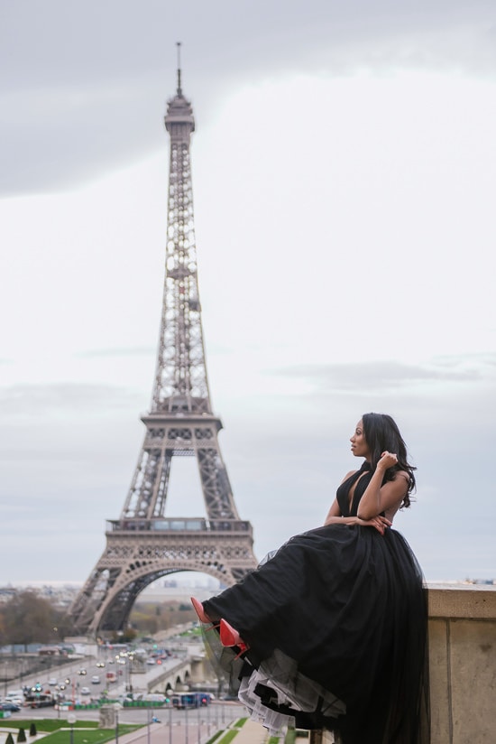 Cute girl wearing Louboutin stilettos posing in front of the Eiffel Tower