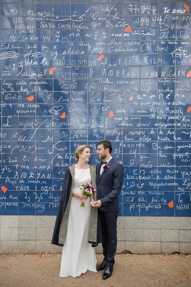 Bride and groom at the I Love You wall in Paris