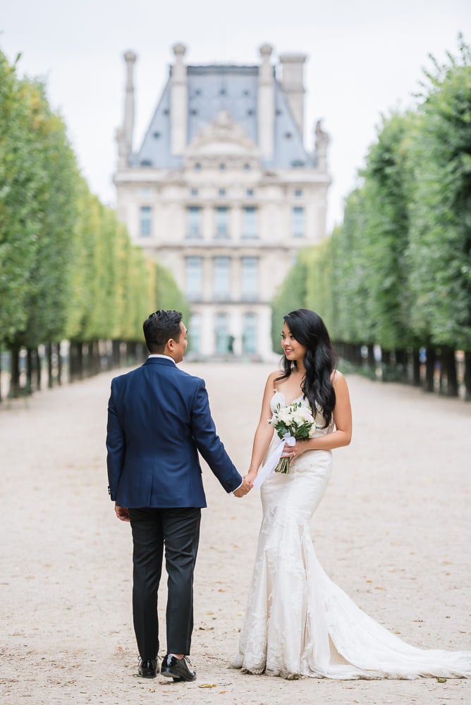 Elope to Paris in the Tuileries gardens. Bride and groom holding hands