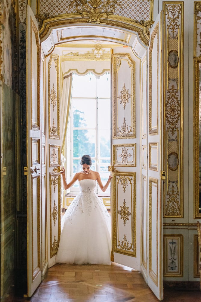 eloping in paris bride in haute couture dior dress opening doors at the chateau de chantilly