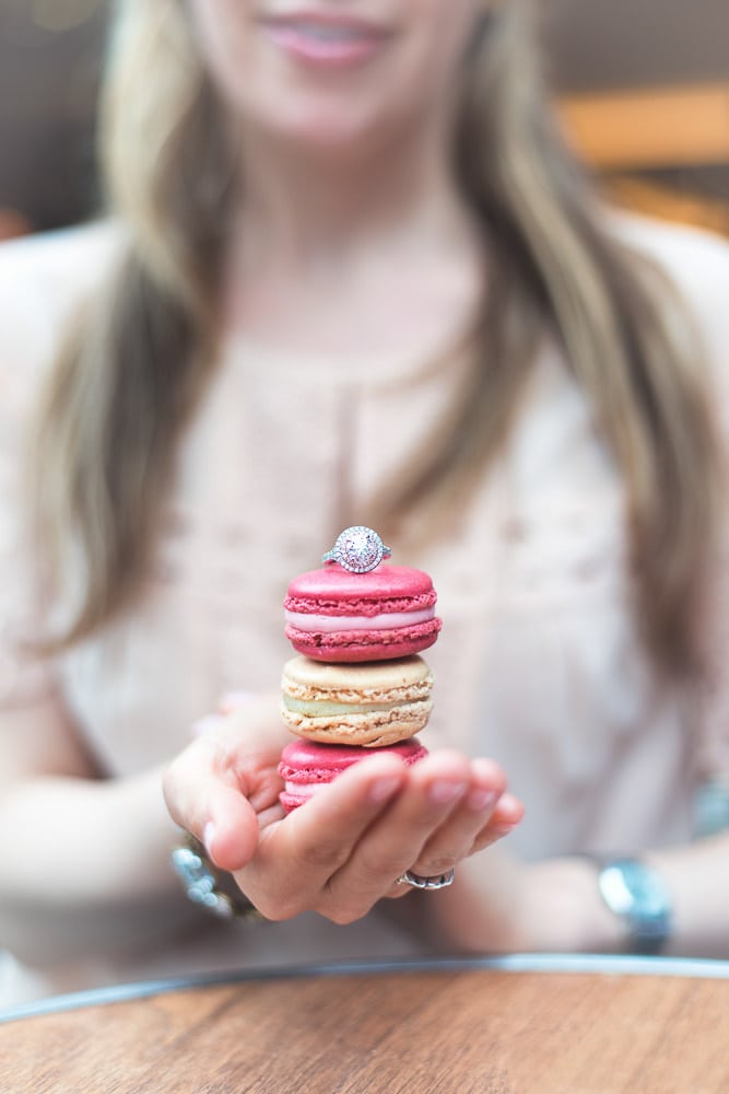 engagement photos paris - cute close-up of girl holding macarons and diamond ring on top