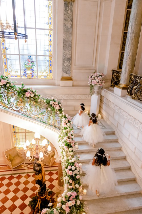 Flower girls walking up the stairs of Shangri La to the wedding ceremony
