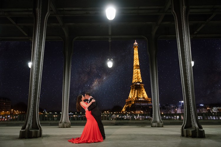 Girl in red dress kissing her fiancé in the City of Lights