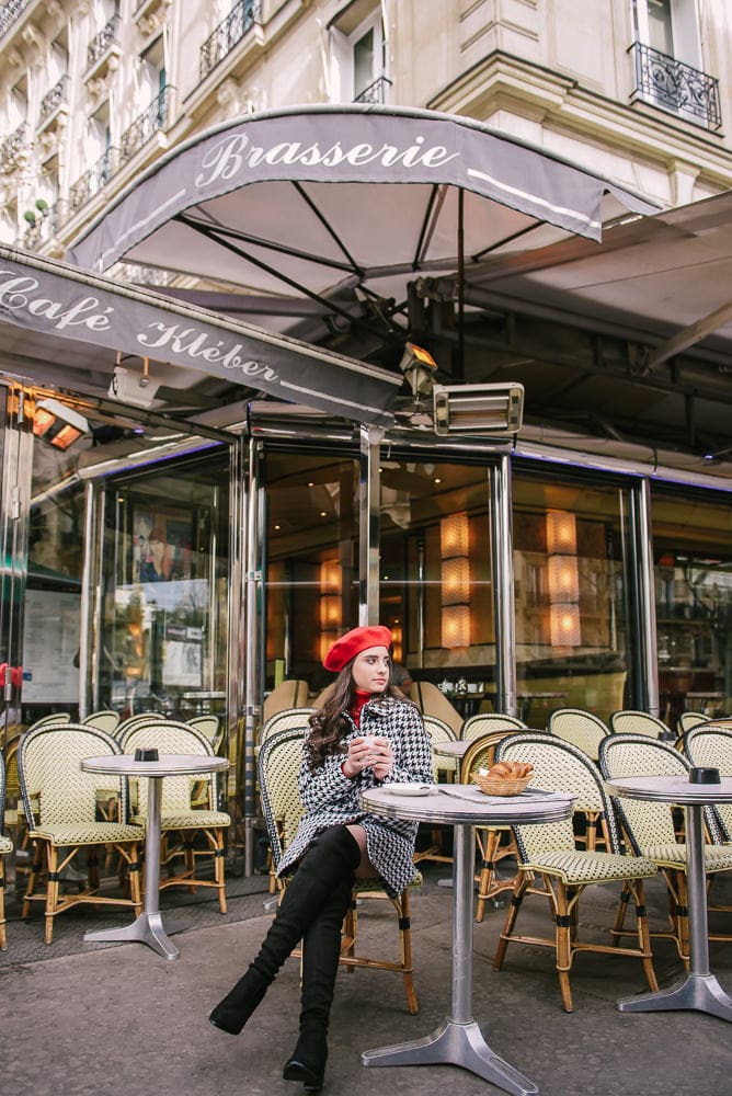 Girl wearing red french beret posing in a parisian cafe for her quince photos