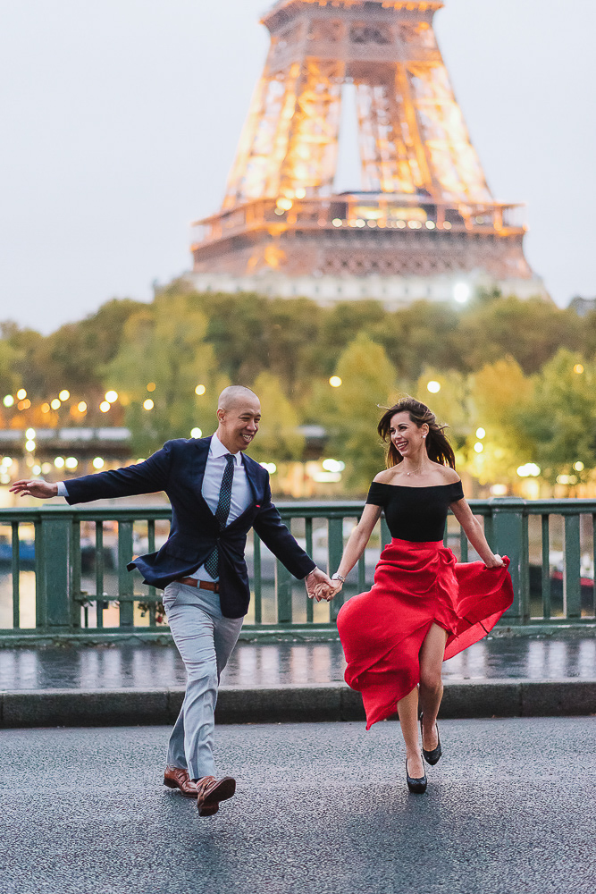 Happy couple running across the street in Paris in one of the most beautiful spots with eiffel tower view