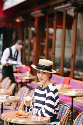 Influencer Fabmuse Diana posing for portraits in a parisian café