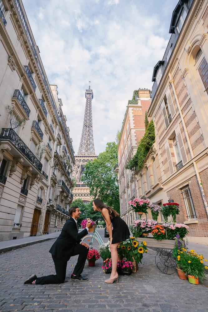 Man proposing to his girlfriend next to a flower cart on rue universite near Eiffel