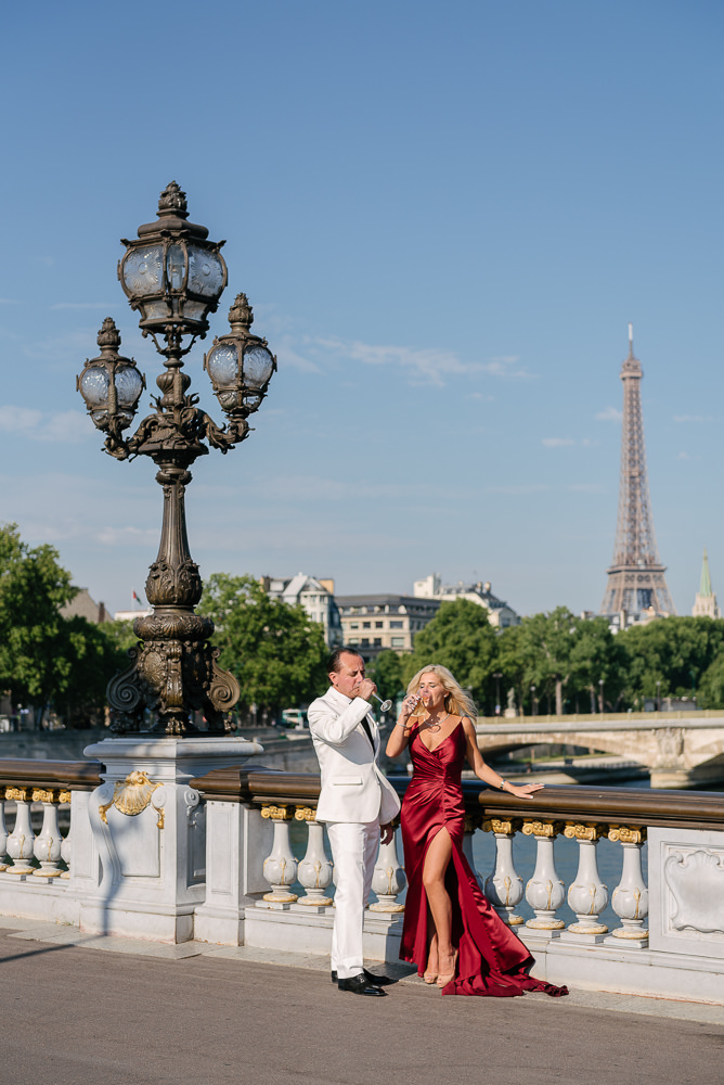 Newly engaged couple celebrating with champagne on the Alexander 3 bridge in Paris
