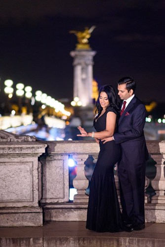 Newly engaged girl looking at engagement ring right after proposal on the Alexander 3 bridge of Paris night photo