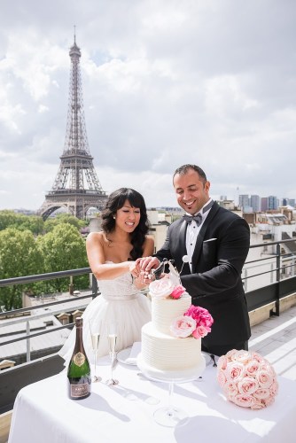 Bride and groom cutting wedding cake on Shangri La terrace with Eiffel Tower in the background