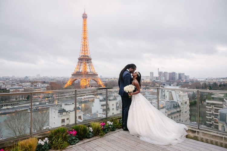 Paris elopement photographer - black bride and groom kissing on the terrace of Shangri La with Eiffel Tower in background