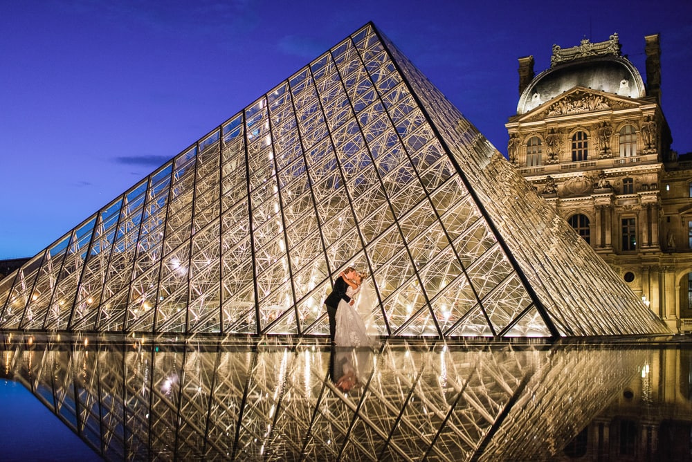 Paris elopement photographer - Creative reflection of bride and groom at the Louvre Museum Pyramid
