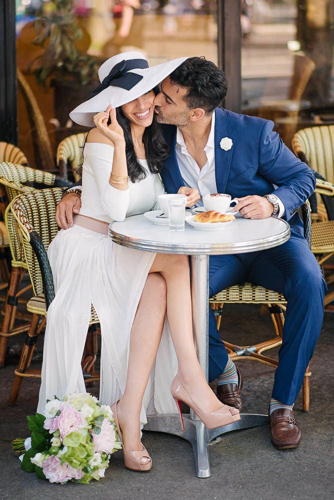paris photographer engagement - beautiful girl with white hat being kissed on the cheek by her fiance