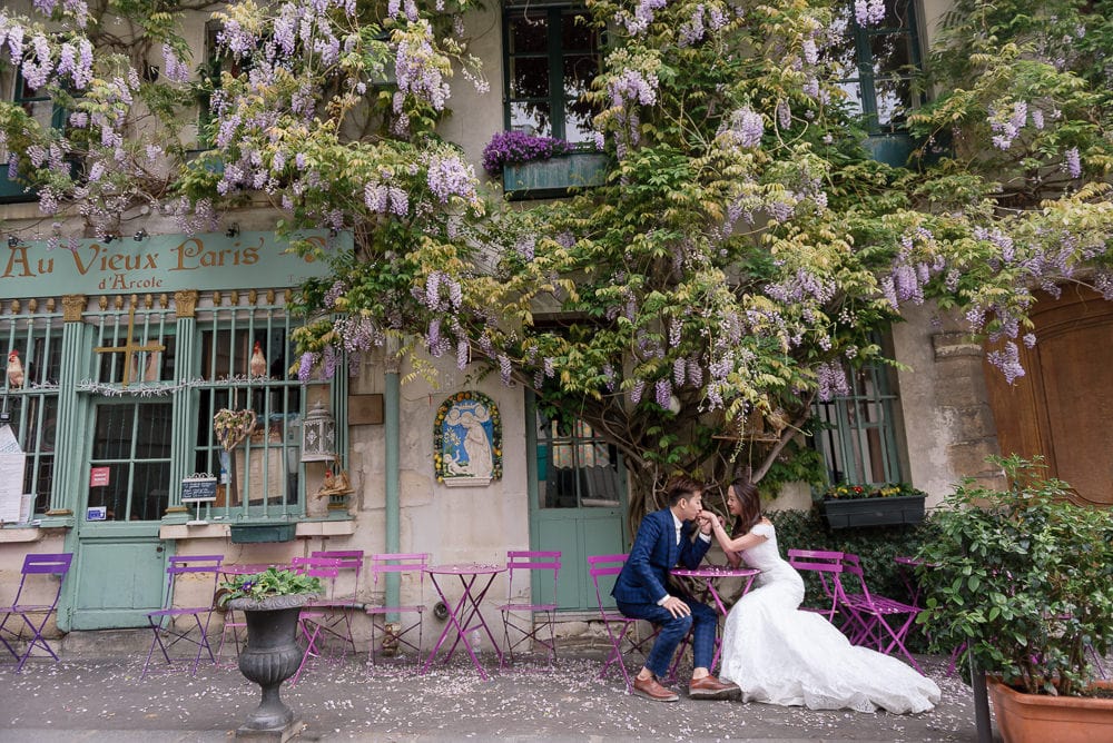 Paris photographer knows hiddel places in the city. Asian groom kissing bride's hand at Au Vieux Paris
