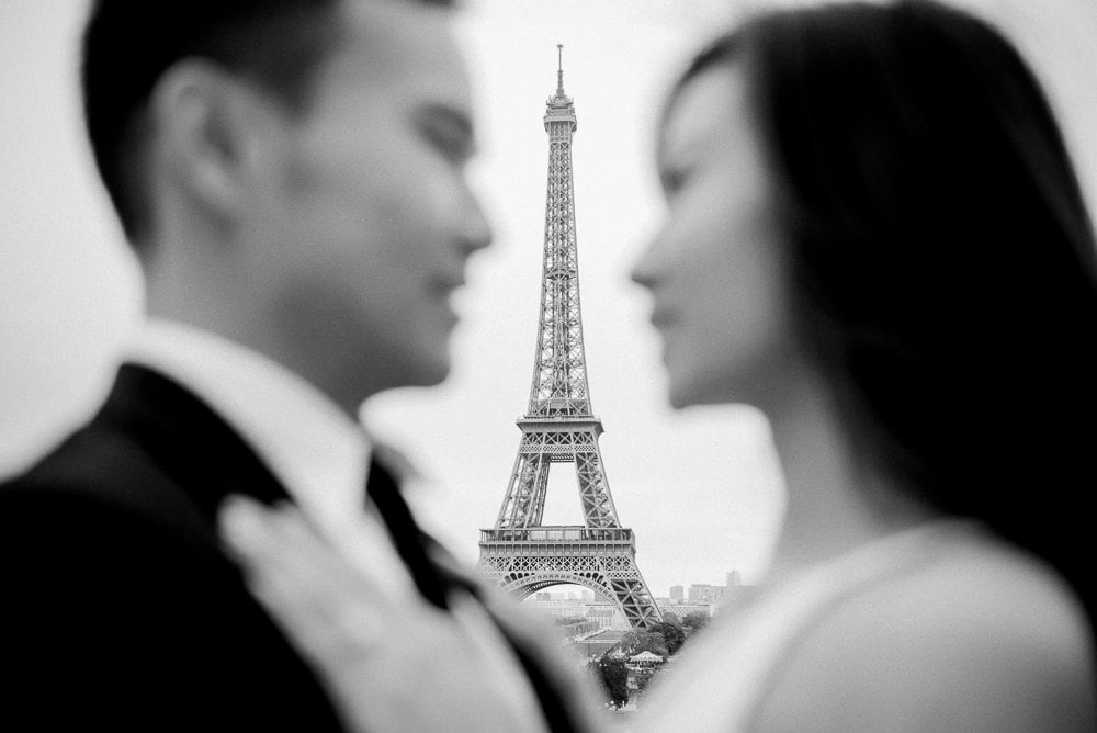 Paris pre wedding photo - Asian bride and groom looking at each other and Eiffel Tower shows in between