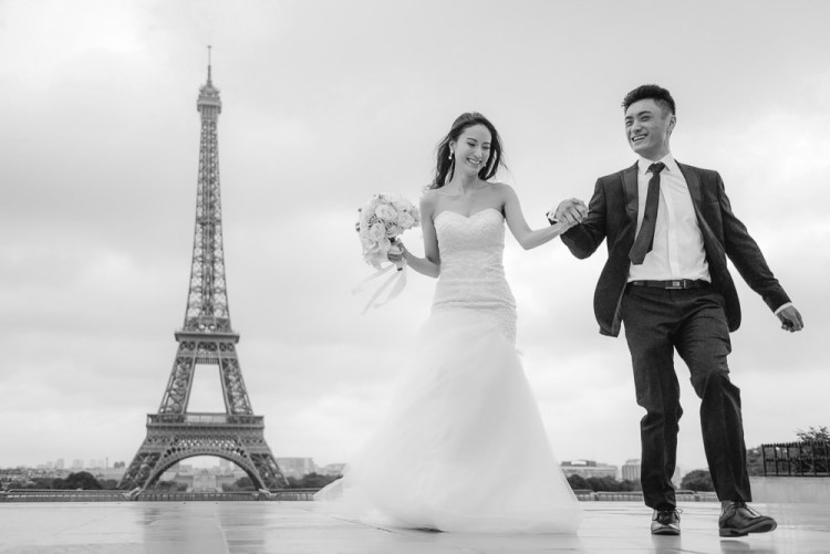 Paris pre wedding photographer - asian bride and groom running away from the eiffel tower