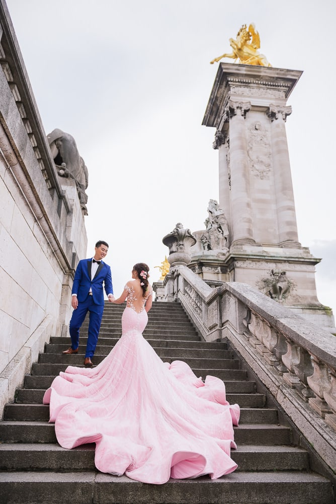 Paris pre wedding photographer - asian bride with huge pink dress posing on the Alexander 3 bridge