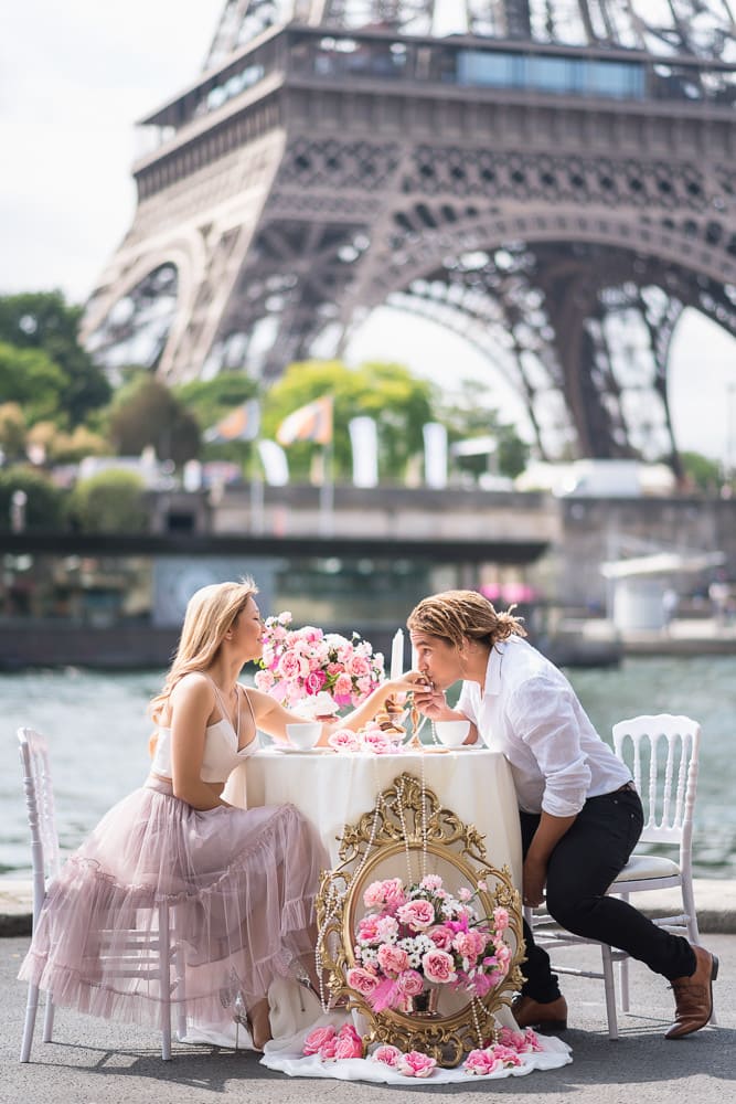 photo shooting couple with beautiful table scape containing roses and candles by the seine river in front of the eiffel tower