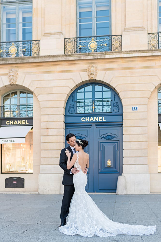 pre wedding photo bride and groom kissing in place vendome in front of chanel store