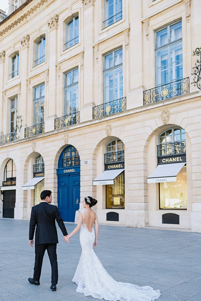 pre wedding pictures poses - bride and groom walking hand in hand in place vendome