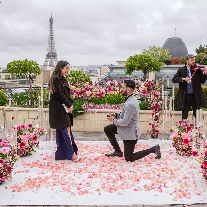 Red flowers romantic setup for surprise engagement on a rooftop in Paris