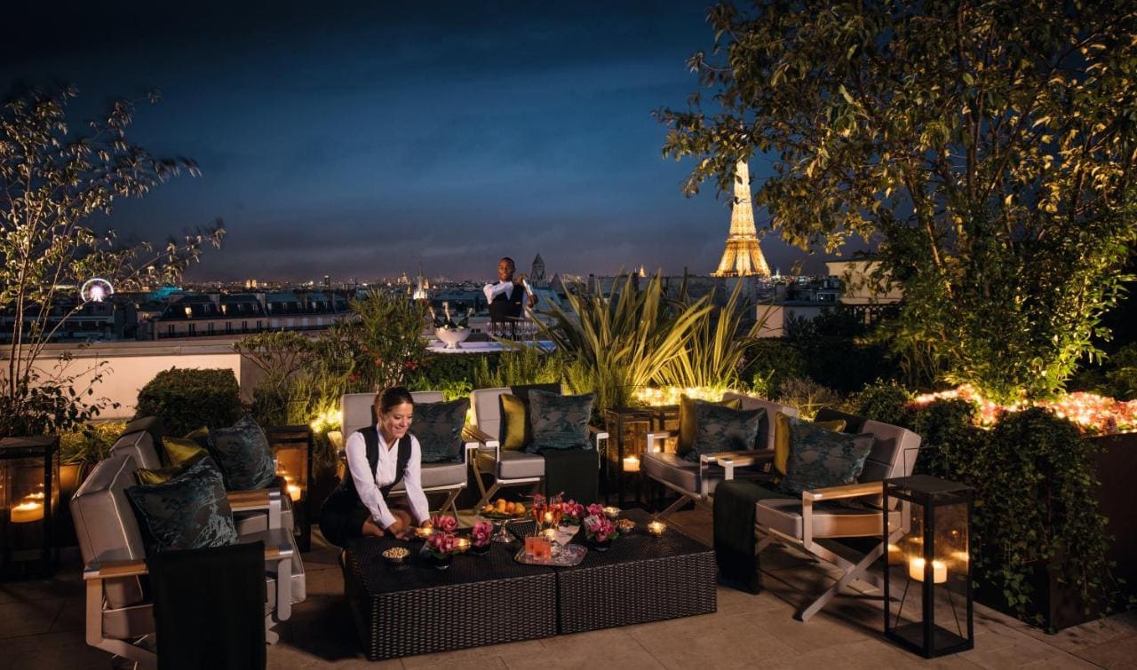 restaurant rooftop Hotel Peninsula Paris at night with a view over the Eiffel Tower