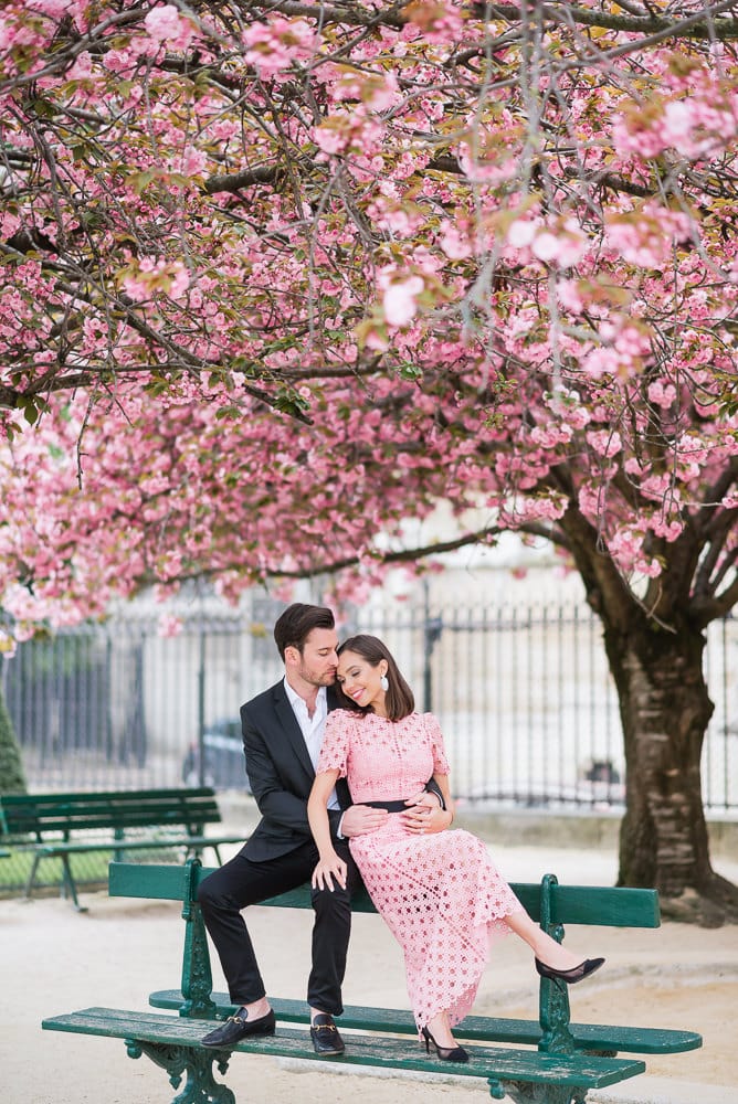 Spring engagement photos in Paris - Beautiful latina girl kissing her fiancé under a cherry blossom in Paris 2
