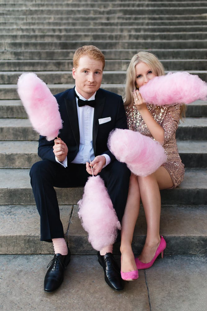 Stylish couple posing for engagement photos with pink cotton candy