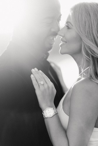 Woman and man smiling at each other during engagement photo session