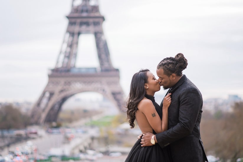Young couple having a romantic kiss in Paris in front of the Eiffel Tower