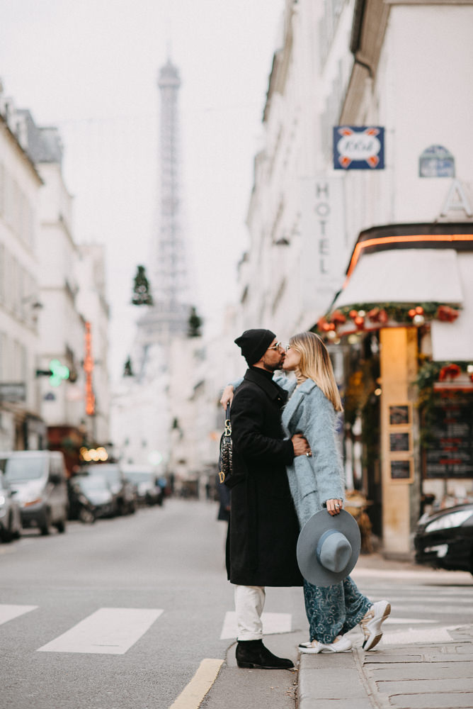 Young couple kissing in the streets of Paris near the Eiffel Tower